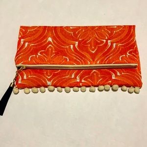 NWOT Orange fold-over Pom Pom clutch